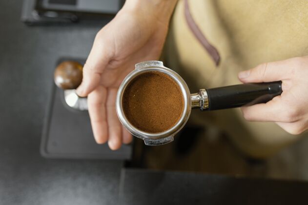 职业女咖啡师手持咖啡机杯的俯视图服务员咖啡师就业