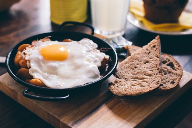 板特写的一顿饭组成的鸡蛋 吐司和豆子在木板上营养鸡蛋菜