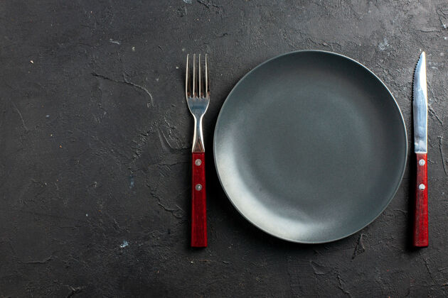 叉子顶视图黑色板叉和黑色表面与复制空间刀刀黑色盘子烹饪