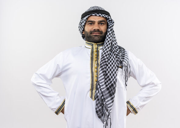 信心身着传统服装的阿拉伯男子站在白墙上 脸上带着自信的微笑男人阿拉伯语穿