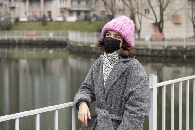 人类湖边城市里戴着医用口罩的女人的正视图人妇女防护
