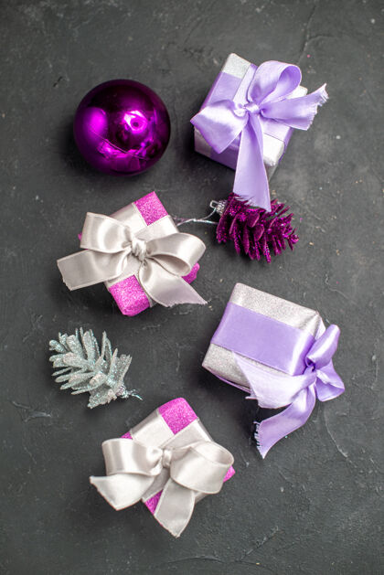 圣诞节顶视图圣诞礼物粉红色和紫色的丝带圣诞树上的玩具黑暗孤立的表面圣诞照片玩具治疗头发幻灯片