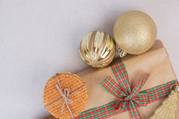 圣诞玩具绳子里的甜饼和礼物 还有白色表面的圣诞金色玩具吃纸食物