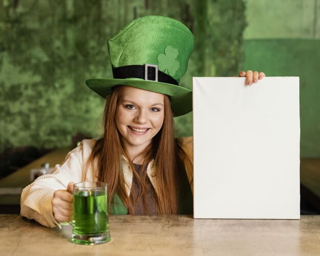 品脱笑脸女人在酒吧庆祝圣帕特里克节的正面图 上面有空白的标语牌和饮料爱尔兰派对饮料