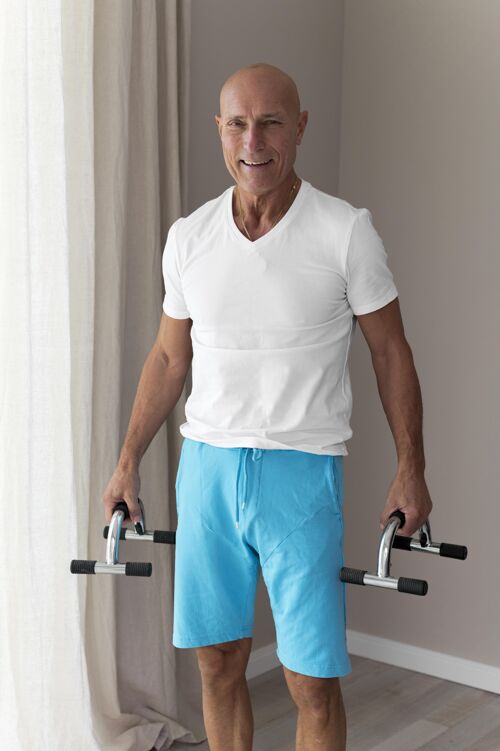 房子高级男士在室内使用健身器材健康成熟老年人