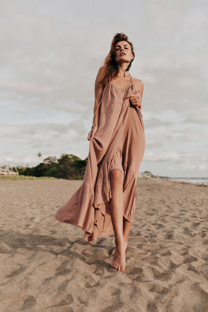 水令人难以置信的长发女模特穿着长裙在海边阳光下的海滩上人海滩热带