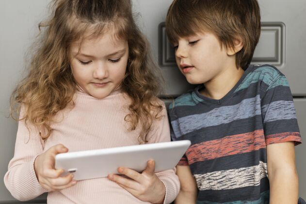 快乐中镜头的孩子们在看平板电脑男孩女孩科技