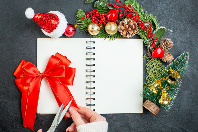 圣诞老人上图是圣诞心情与杉树枝圣诞老人帽圣诞树红丝带笔记本上的黑暗背景视图笔记本圣诞心情