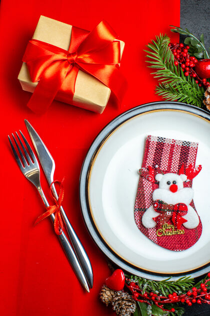 袜子新年背景特写镜头与xsmas袜子上的餐盘餐具套装装饰配件杉木树枝旁边的礼物上的红色餐巾餐盘叉子冷杉