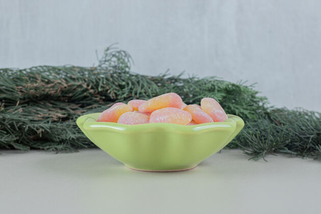 小吃一个装满心形果冻糖果的绿色盘子吃形状糖
