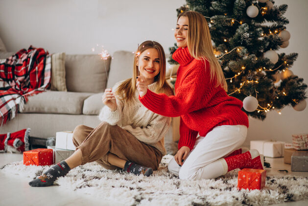 圣诞盒两个女孩朋友庆祝圣诞节红色毛衣快乐的女人传统