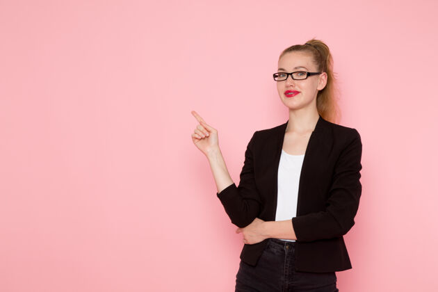 工作身穿黑色夹克的女上班族在粉色墙上微笑着摆姿势的正面图专业人士个人企业家