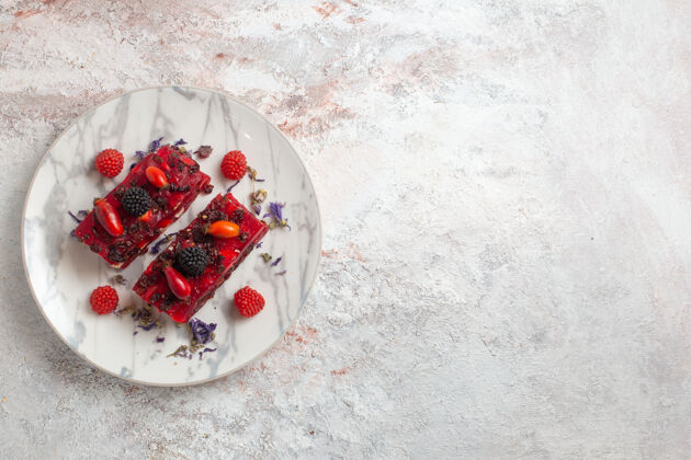 霜顶视图浆果蛋糕片与红色奶油糖衣和新鲜浆果的白色表面饼干顶部杯子