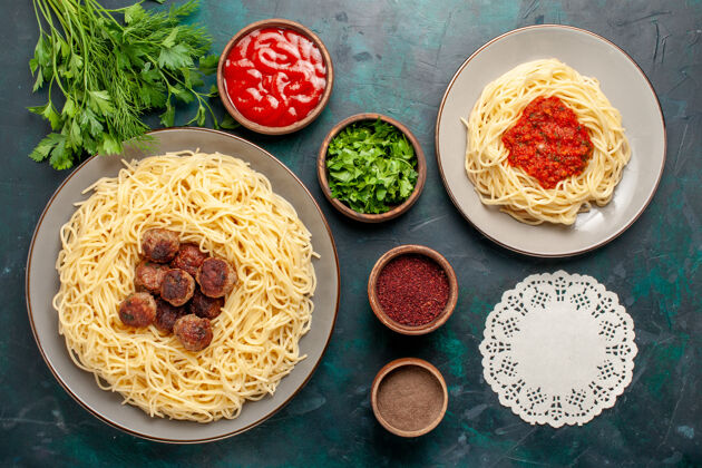 肉俯视图煮熟的意大利面食 深蓝色表面有肉和调味品菜肴酱汁面食