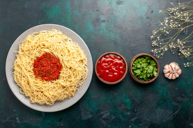 肉俯瞰意大利面 蓝色表面有肉末 番茄酱和调味料面团烹饪食物