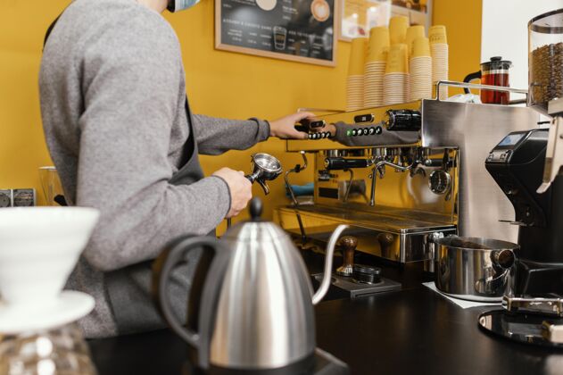服务员在咖啡馆工作的男咖啡师的侧视图职业咖啡店咖啡馆