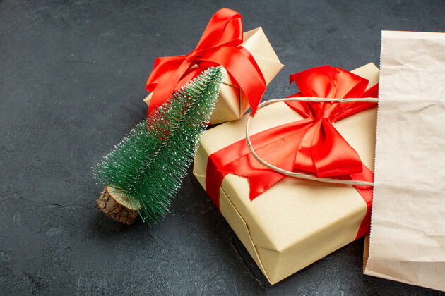 购物侧视图美丽的礼物与红丝带和圣诞树在一个黑暗的桌子上包装景观圣诞节