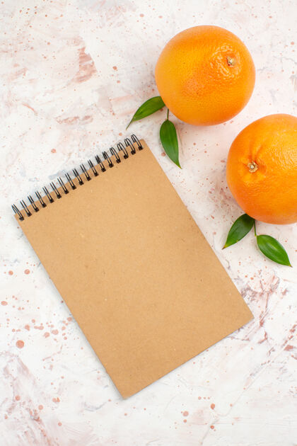 甜橙顶视图新鲜橙子一个记事本在明亮的表面维生素观点柑橘