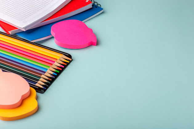 学校前视图彩色铅笔与复印机在蓝色的表面画画钢笔彩色