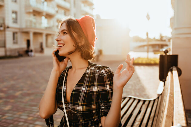 短发穿着优雅衣服的正面女模特在享受秋日穿着红色贝雷帽的漂亮卷发女人在电话里交谈的户外照片自拍卷发法国