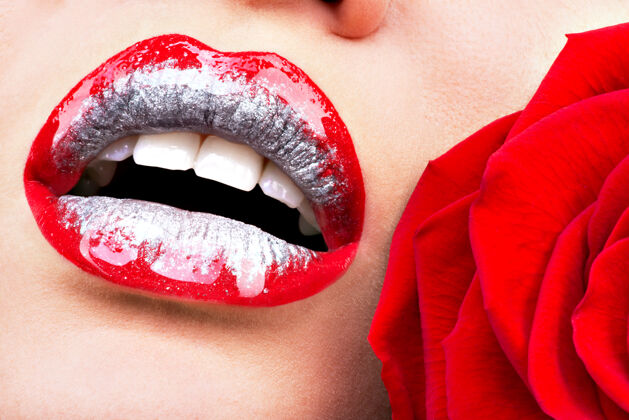 关闭闭上美丽的女性嘴唇与闪亮的红色光泽唇膏和玫瑰感官制作性感