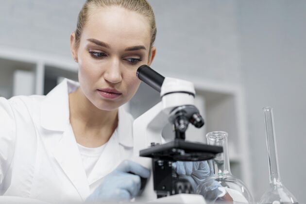 研究女研究员在实验室里拿着显微镜显微镜技术员实验室技术员