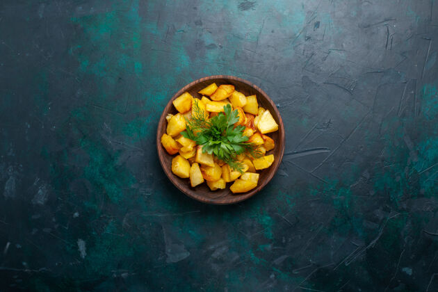 顶部俯视图烹饪土豆片与绿色内棕色盘子在深蓝色的表面食物生的正餐
