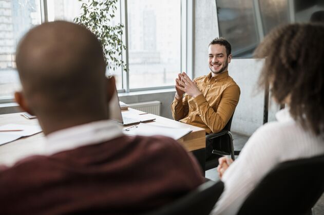 工作笑脸人在开会时和同事说话办公室专业职业
