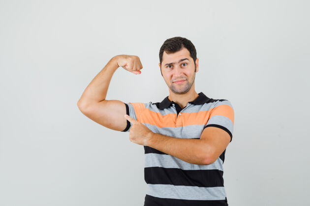 胡须穿着条纹t恤的年轻人展示了他的手臂肌肉 看起来很有力量T恤成功男人