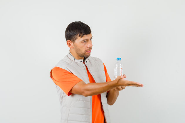专业男青年穿着t恤 夹克里拿着一瓶水 伸出手 俯瞰前方T恤男人伸展