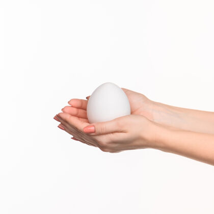 人类女人的手上拿着一个白鸡蛋椭圆形道具手