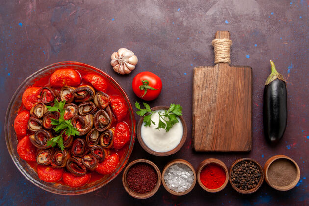 饭菜顶视图烹饪蔬菜餐美味的西红柿和茄子与调味品在黑暗的桌子上帽子桌子食物