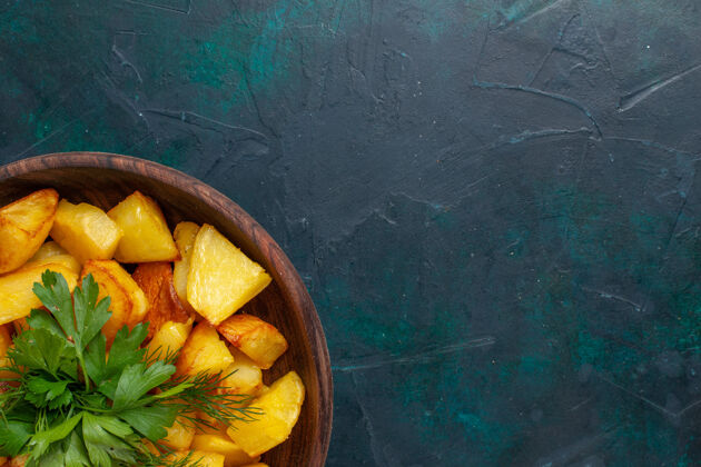 可食用水果顶部近距离观看熟土豆片与绿色内棕色盘子在深蓝色的表面烹饪切片柑橘