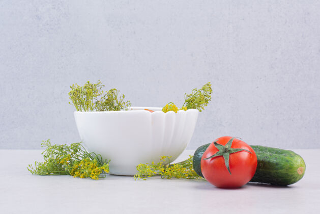 顶视图把黄瓜和西红柿切成片放在白碗里 配上绿色蔬菜番茄切成熟