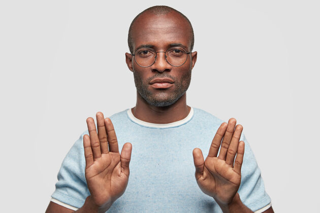 吸引严肃的黑皮肤男性显示停止手势拒绝风格表情