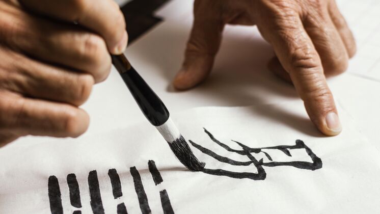 毛笔在白纸上写中国符号的人的特写镜头书法水墨安排