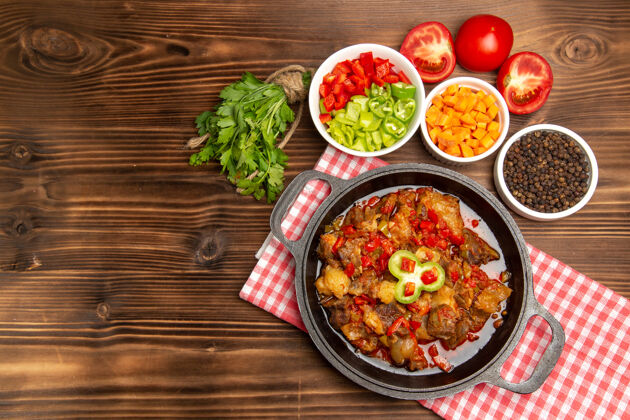 胡椒粉在棕色桌子上俯瞰煮熟的蔬菜餐 包括蔬菜酱和肉美味包括生的