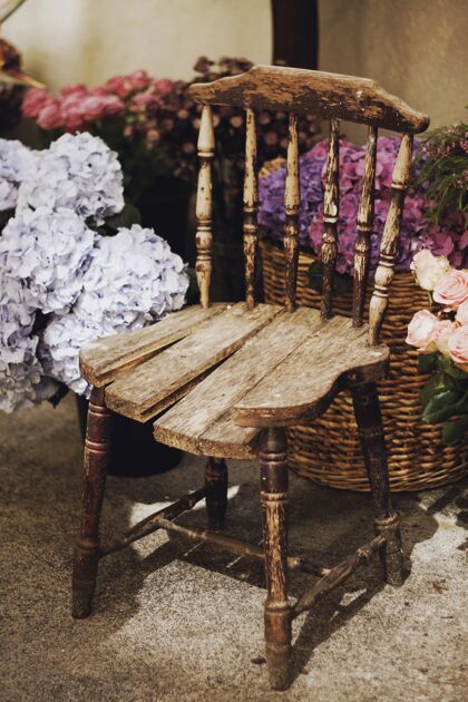 花卉垂直特写镜头一个老式木椅子周围的花篮复古手工稻草