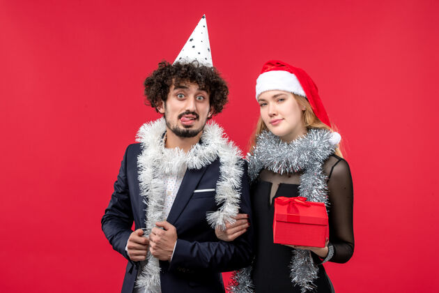 风景红墙圣诞爱情派对上赠送新年礼物的年轻夫妇的正面图漂亮服装服装