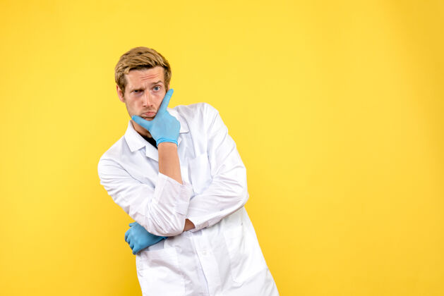 医学正面图黄色背景上的男医生思考柯维德-大流行的健康医生成功行政人员冠状病毒