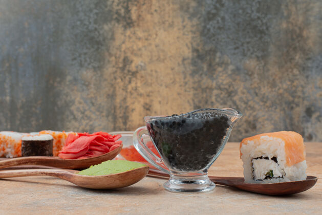 海一套美味的寿司卷 汤匙和酱油放在大理石表面蔬菜新鲜吃