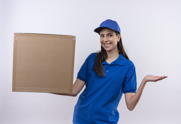 手臂身着蓝色制服 头戴鸭舌帽 手拿纸板箱 微笑自信 手臂微笑的年轻送货员交货制服年轻