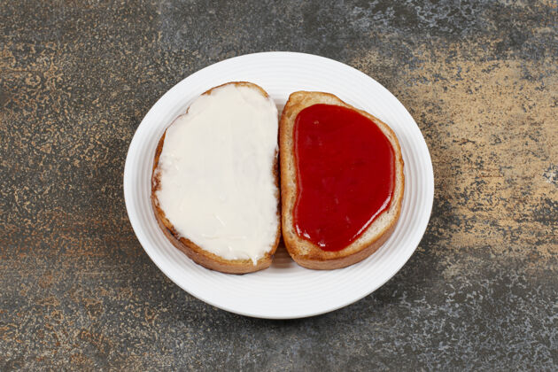 切片在白色盘子上烤草莓酱和酸奶油果酱美味早餐