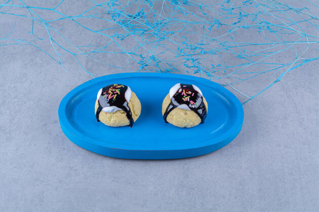 吃一块蓝色的木板 上面放着巧克力糖浆和五颜六色的小甜饼好吃可食用糖浆