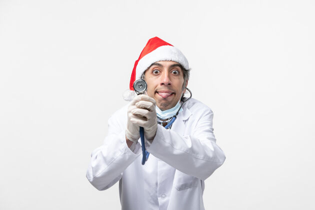 病毒正面图白色地板上带听诊器的男医生新年快乐职业圣诞节冠状病毒