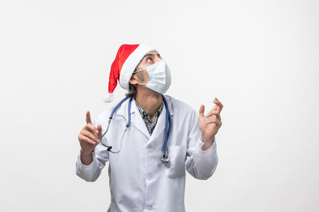 视图正面图白色地板上戴口罩的男医生圣诞节男人医药