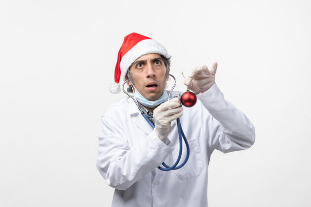 冠状病毒正面图男医生拿着玩具白墙病毒冠状病毒健康过年视图圣诞节医药