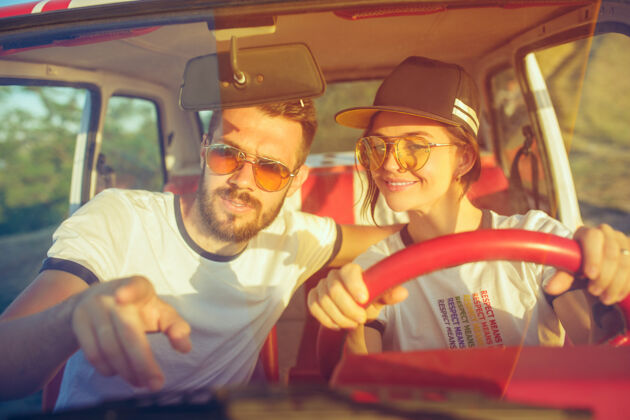 在一起一对谈笑风生的浪漫情侣坐在车里 外出旅行大笑生活方式浪漫