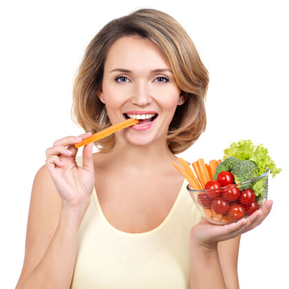 肖像美丽健康的年轻女人在吃沙拉-白色隔离漂亮食物微笑