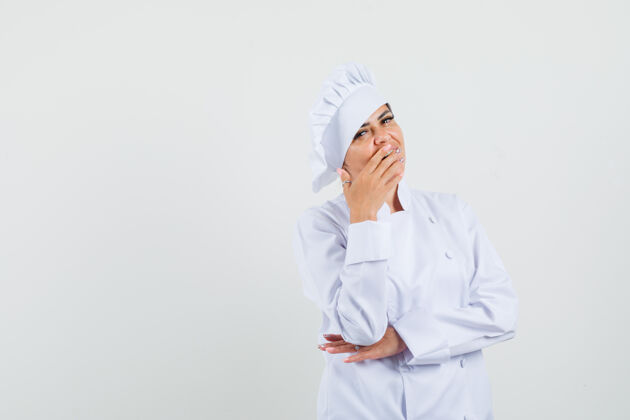 女性穿着白色制服的女厨师手捂着嘴 看上去很惊讶服务食物手
